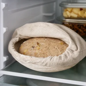 Pagnotta di lievito madre coperta in lievitazione a freddo nel banneton in frigorifero