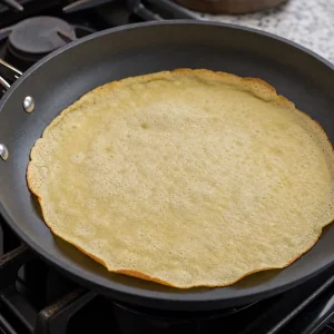 Duenner niederlaendischer Pfannkuchen gart bis die Oberseite trocken und die Raender golden sind