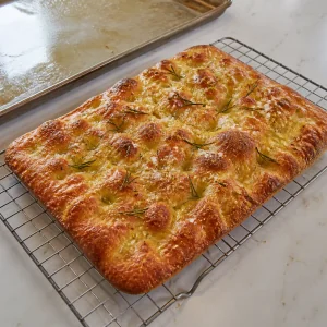 Gebackene roemische Pizza bianca kuehlt knusprig und golden auf einem Gitter ab