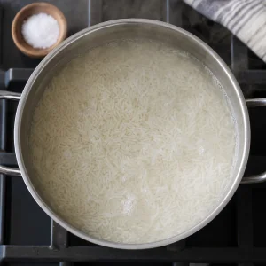 Basmati rice simmering in salted water until fluffy.