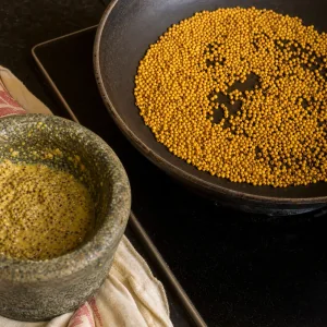 Semi di senape tostati accanto a pasta di senape grossolana