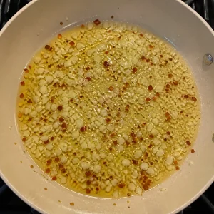 Czosnek i płatki chili skwierczą w oliwie