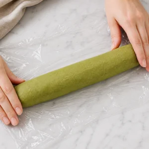 Impasto di shortbread al matcha formato a cilindro su pellicola