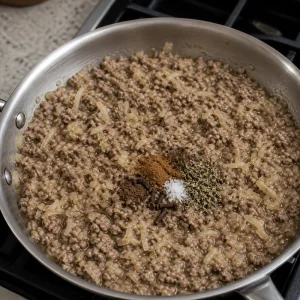 Grated potato and spices stirred into the simmering meat filling