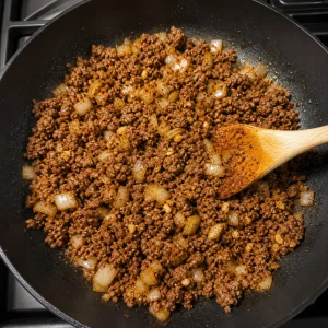 Cipolla a dadini, aglio, cumino e peperoncino in polvere mescolati alla carne rosolata