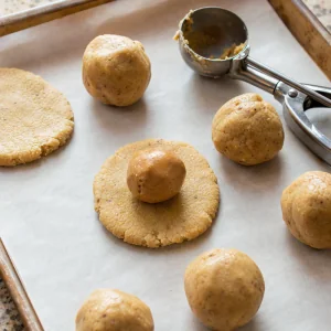 Step 5: cookie dough disks wrapped around chilled nut butter filling balls.