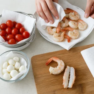 Tomatoes, mozzarella, and shrimp dried and prepped for skewers