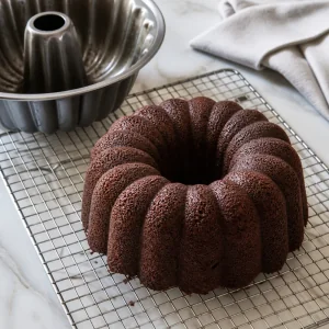 Undecorated chocolate Bundt cake cooling on a wire rack