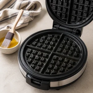 Piastra per waffle aperta spennellata con burro fuso prima della pastella.