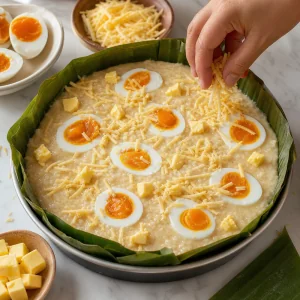 Bibingka crue garnie d’œufs de cane salés, de fromage et de beurre.