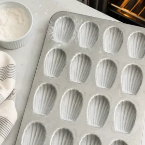 Greased and floured shell-shaped madeleine pan ready for batter