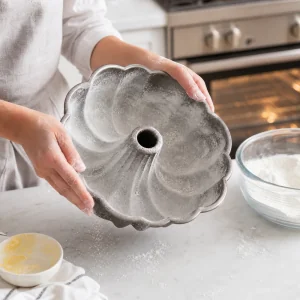 Greasing and flouring a bundt pan for lemon poppy seed cake.