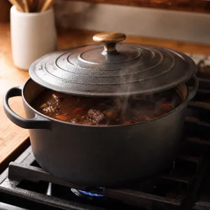 Casseruola coperta con stufato di manzo che sobbolle a fuoco basso.