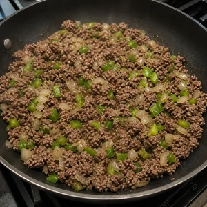 Ground beef browning with onion and green bell pepper