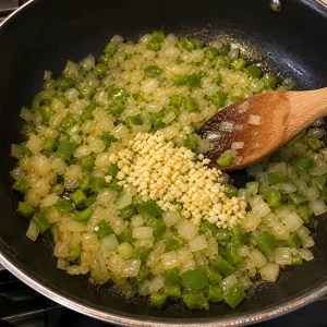 Minced garlic stirred into onion and green bell pepper