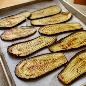 Roasted eggplant slices browned in spots on parchment