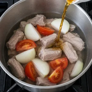 Очищенные свиные ребра с луком и томатами, к которым добавляют рыбный соус