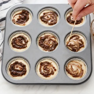 Cinnamon mixture swirled into each keto muffin cup with a toothpick