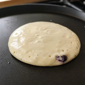 Fresh batter poured over blueberry cream cheese filling to seal the pancake