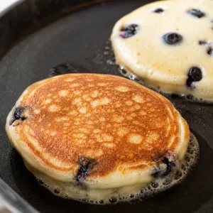 Stuffed pancake flipped on the skillet with a golden brown surface