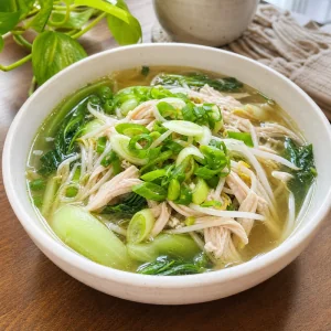 Ingwer-Haehnchensuppe serviert mit Mungbohnensprossen und Fruehlingszwiebeln