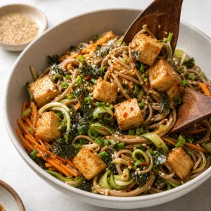 Finished soba noodle salad topped with tofu and nori