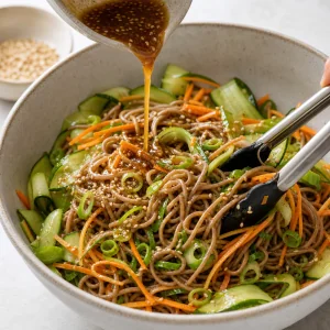 Sesame soy dressing poured over soba noodles and vegetables