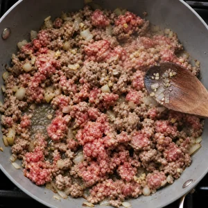 Carne bovina e suina moida dourando com cebola e alho na frigideira