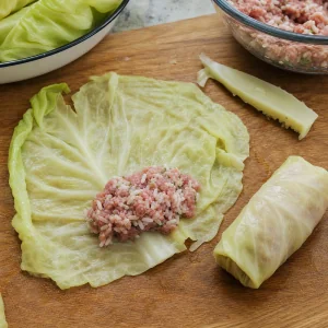 Recheio de carne e arroz colocado sobre folha de repolho aparada para enrolar