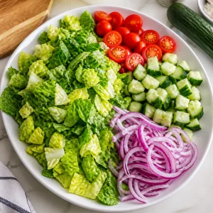 접시에 담긴 로메인, 토마토, 오이, 적양파