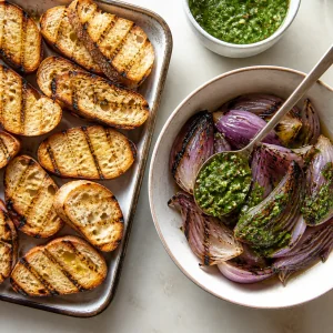Grilled baguette slices and red onion with chimichurri