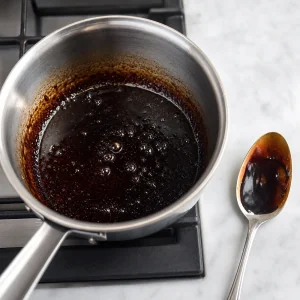 Vinagre balsâmico reduzindo numa pequena panela até ficar brilhante e xaroposo