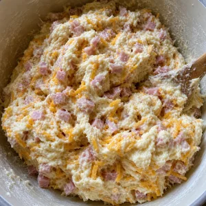 Sticky biscuit dough folded with diced ham and shredded cheddar cheese