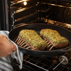 Lammkarrees mit Kraeuterkruste braten mit den Knochen nach unten im Ofen