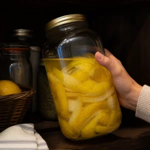 Sealed jar of lemon peel infusion stored in a cool dark pantry