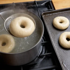 Bagels crus a ferver e a serem retirados com uma escumadeira