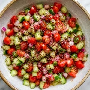 Tomato cucumber salad seasoned in a bowl