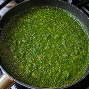 Green spinach sauce simmering in a skillet