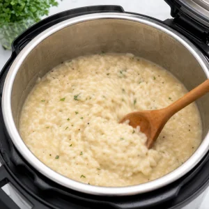 Cooked risotto stirred vigorously in the open Instant Pot until creamy.