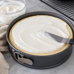 Sour cream topping spread smoothly over the cheesecake.