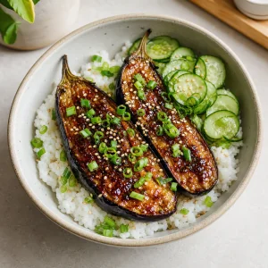 Miso glazed eggplant rice bowl with cucumber, scallions, and sesame seeds