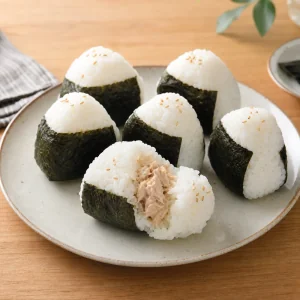 Finished tuna mayo onigiri wrapped in nori on a plate