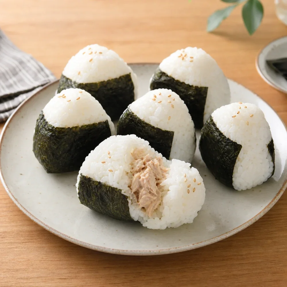 Finished tuna mayo onigiri wrapped in nori on a plate