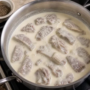 Cooked lamb pieces warming in creamy yogurt sauce