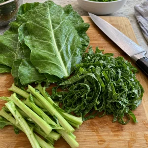 Collard greens sliced into thin ribbons on a cutting board