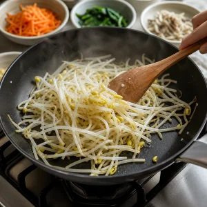 Germogli di soia saltati brevemente in padella calda per bibimbap coreano di manzo.