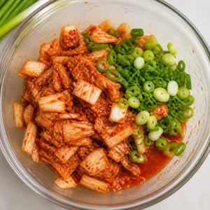 Chopped kimchi and sliced scallions mixed in a bowl