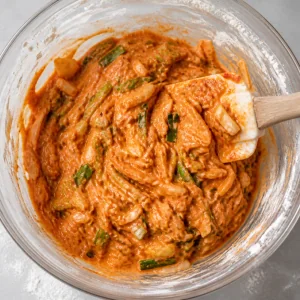 Thick kimchi pancake batter folded with a spatula