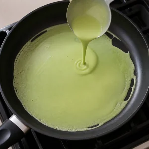 팬에 얇게 퍼지는 초록 판단 반죽