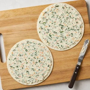 Crema di formaggio con verdure nascoste spalmata fino ai bordi delle tortillas